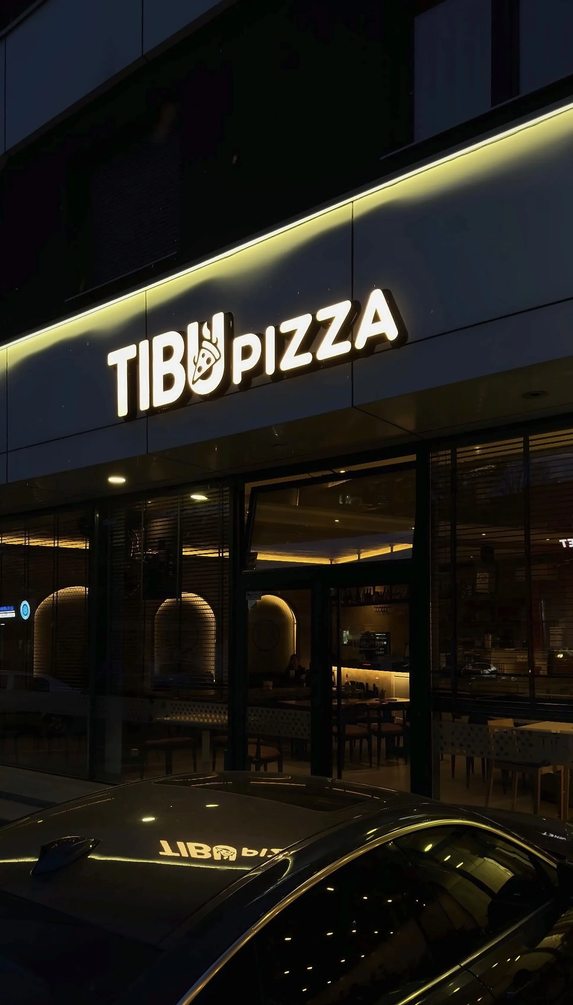 Fasada e TIBU pizza natën, me tabelën e ndriçuar